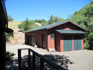 Garage with extra room and wood storage.