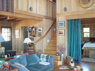 Living room with entry, stairs and master bedrwoom in Backgound.